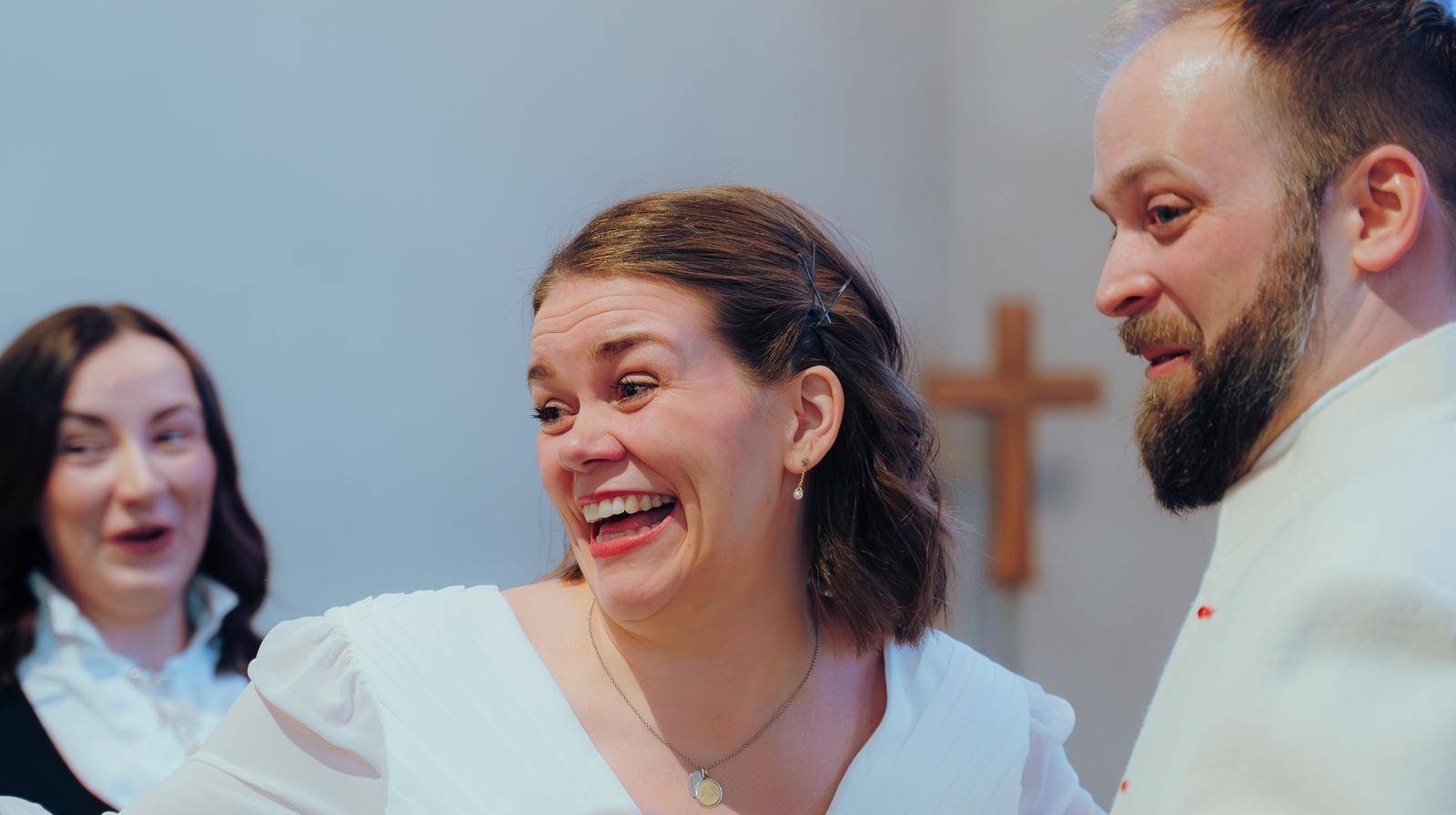 Bilde av et brukepar som smiler. Foto: Den norske kirke / Rasmus Bell Andreassen