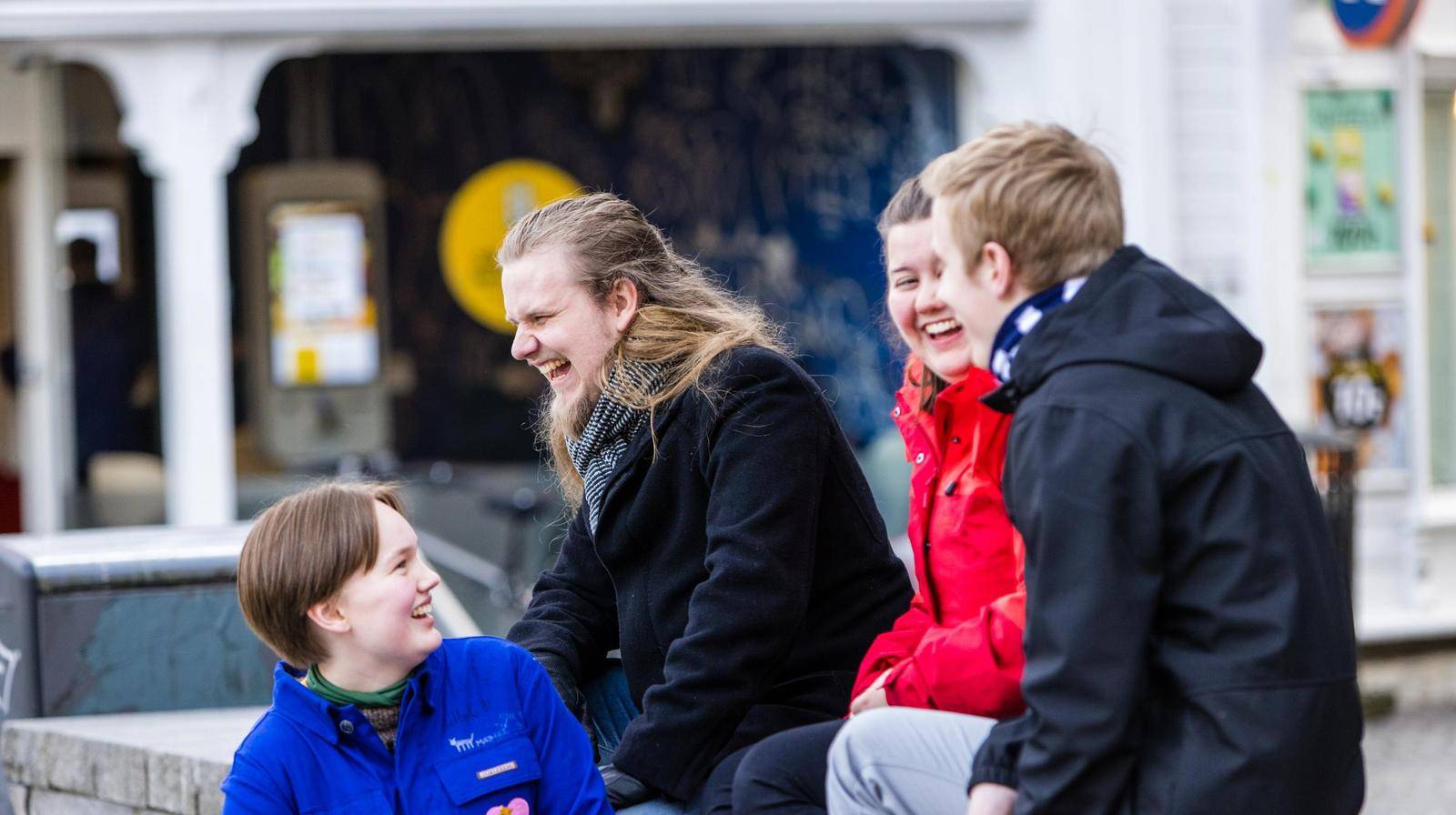 Fire unge mennesker smiler og ler. Foto: Marius Vervik