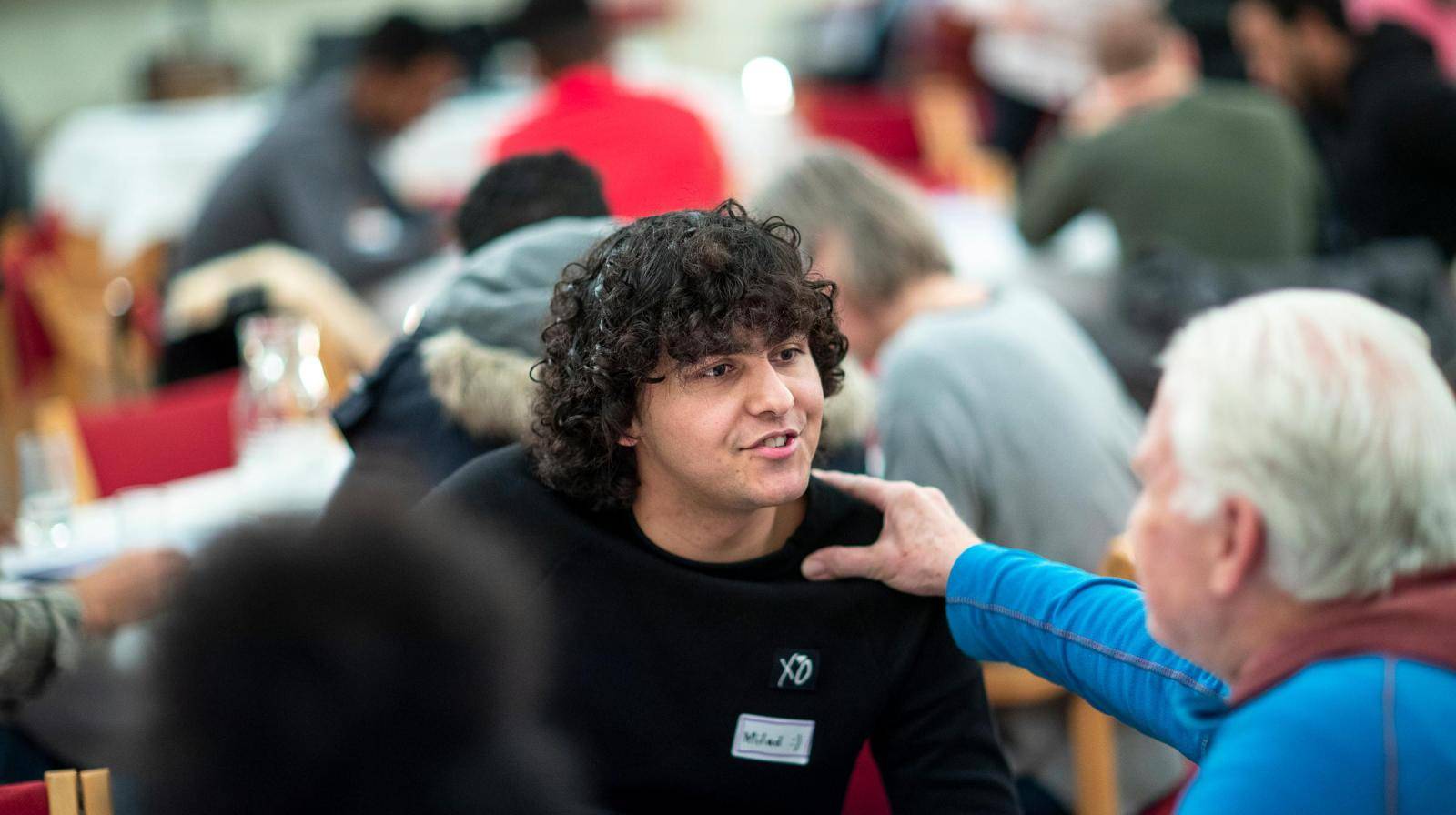 En ung gutt i samtale med en eldre mann. Foto: Bo Mathisen